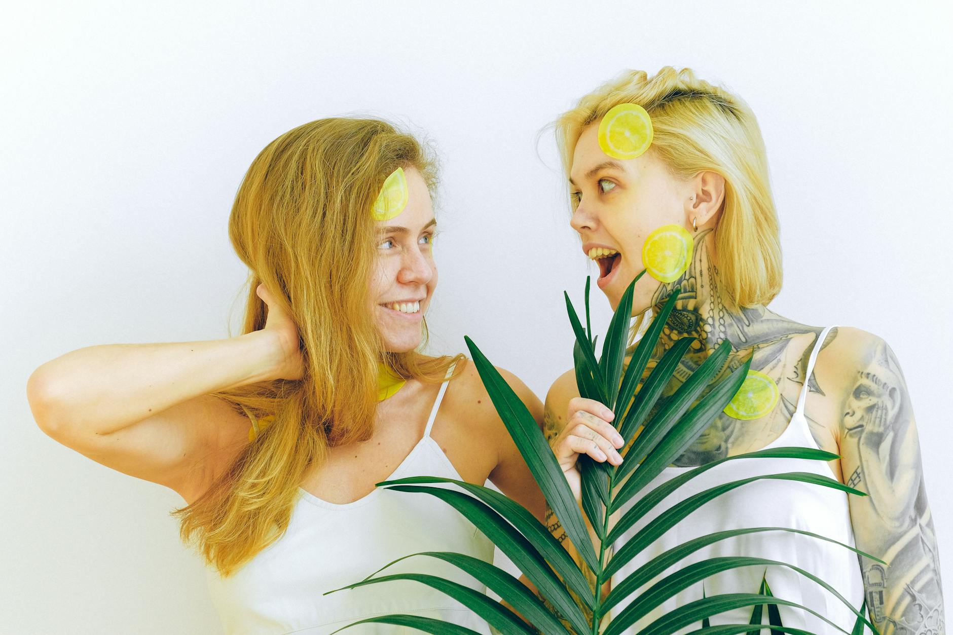Two women smiling together with fresh lemons, expressing joy and vitality after recovery