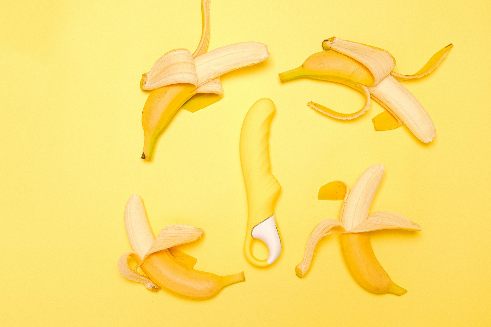 Colorful adult toys including vibrators arranged on a bright surface