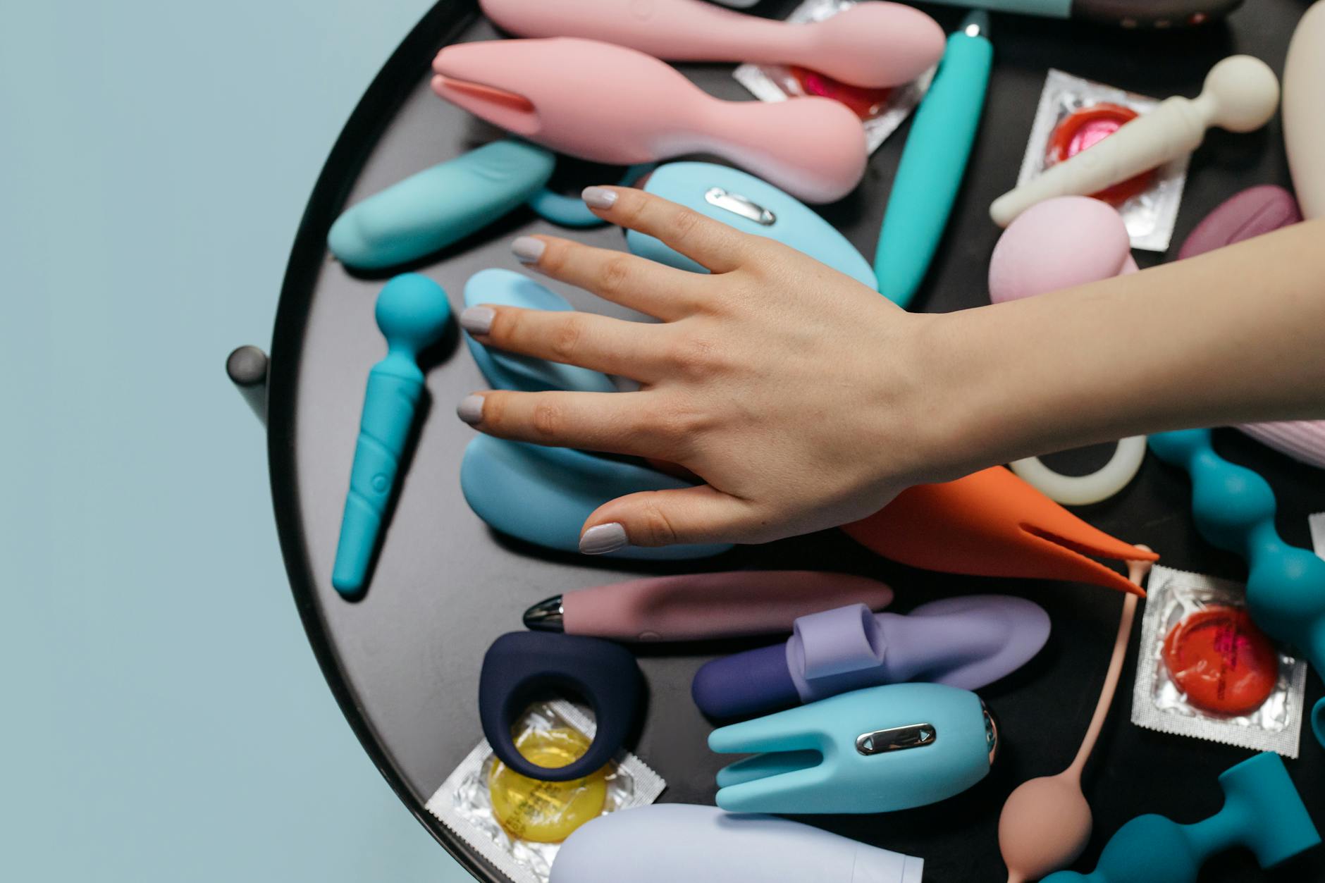 Close-up of hands holding a sleek vibrator, representing safe pleasure with endometriosis