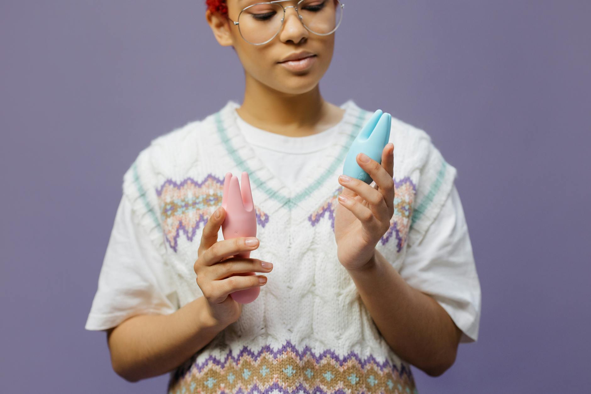 Woman holding vibrators contemplatively, representing reconnection with desire