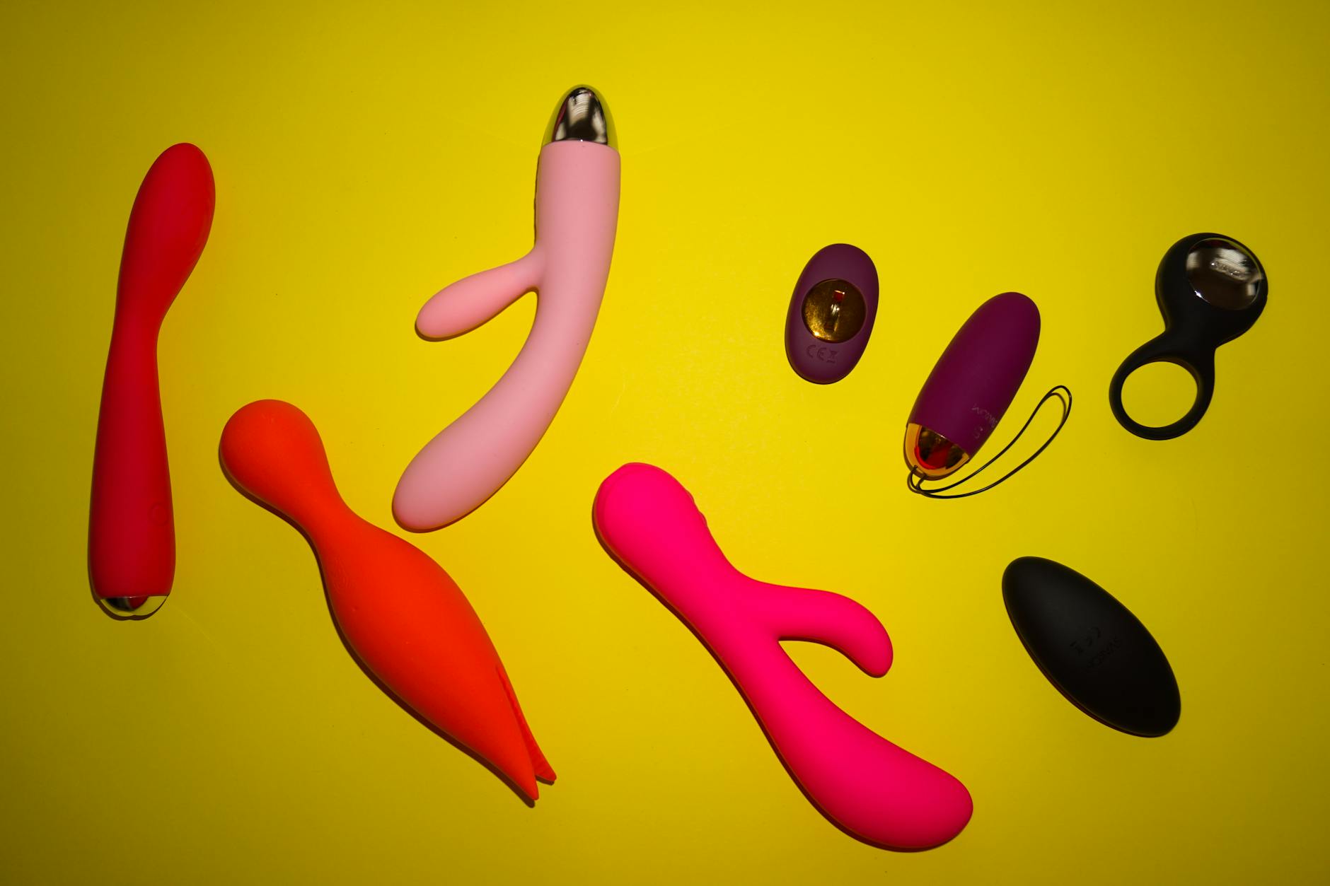 Bright yellow silicone vibrator surrounded by bananas on a yellow background, symbolizing pleasure and intimate exploration